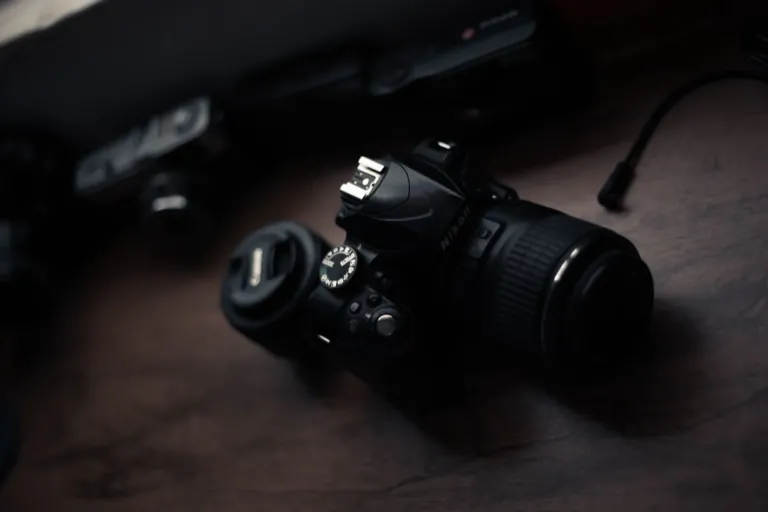 Zwarte Nikon spiegelreflexcamera met zoomobjectief op een donkere houten tafel