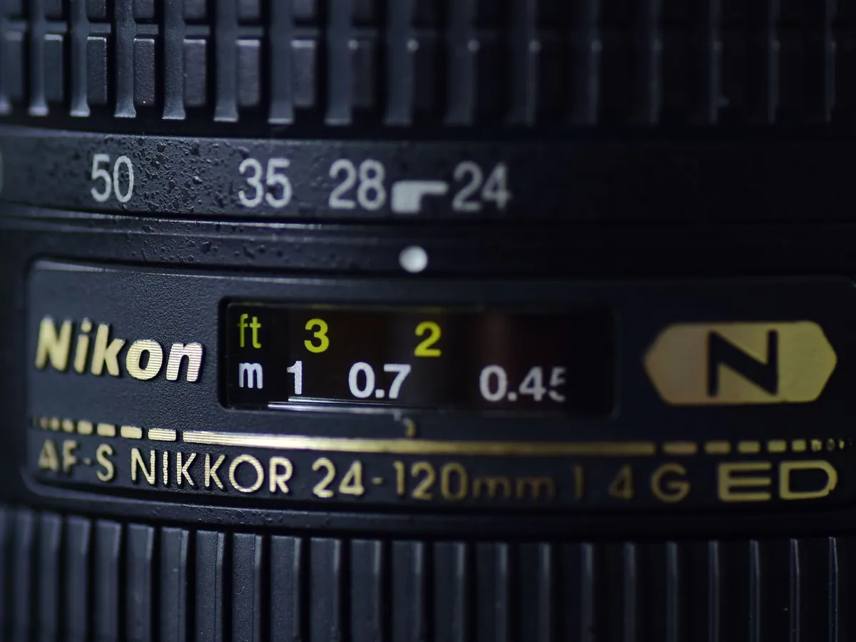 Close-up van een AF-S Nikkor zoomobjectief met afstandsschaal en brandpuntmarkeringen