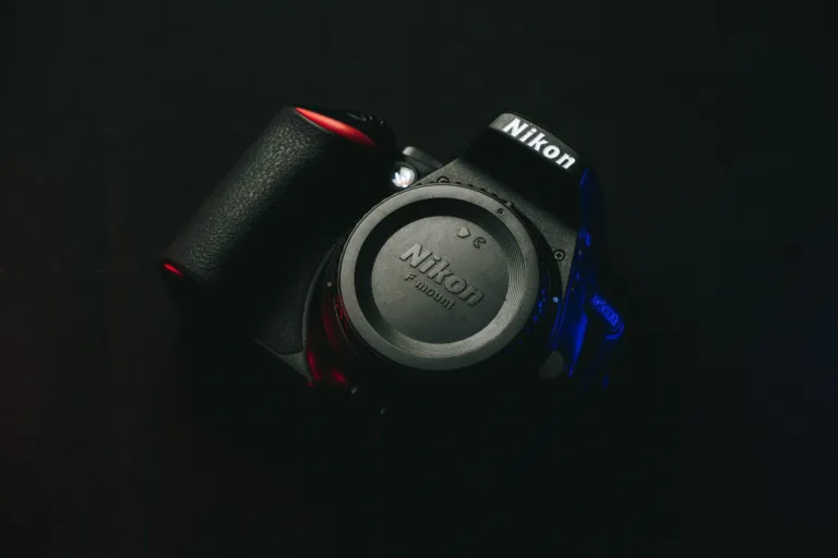 Nikon-camerabody met bodydop van bovenaf gefotografeerd op een donkere ondergrond