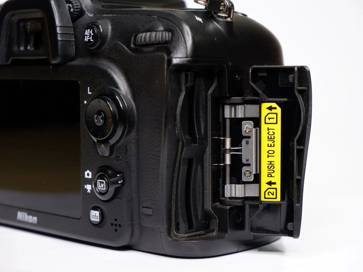Achterkant van een Nikon-spiegelreflex met geopende klep van het geheugenkaartvak