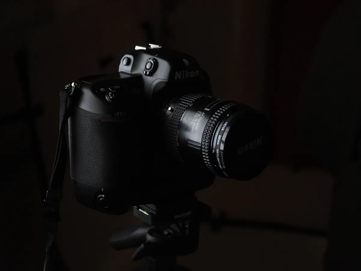 Nikon-spiegelreflexcamera met objectief op een statief in een donkere studio