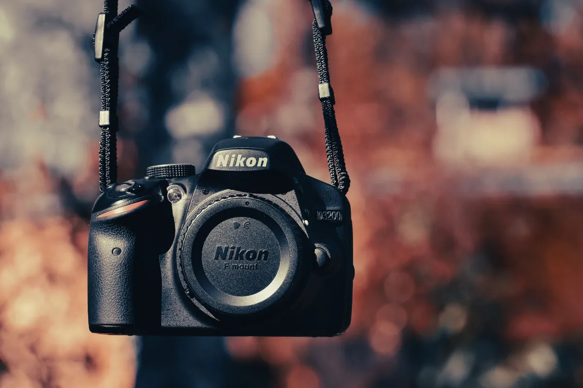 Nikon spiegelreflexcamera met herfstkleuren op de achtergrond
