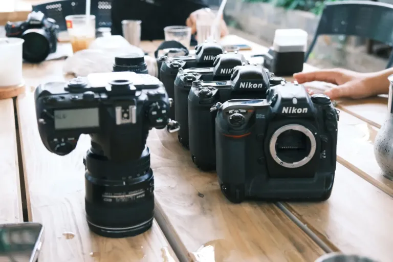 Meerdere Nikon spiegelreflexcamera's naast elkaar op een houten tafel